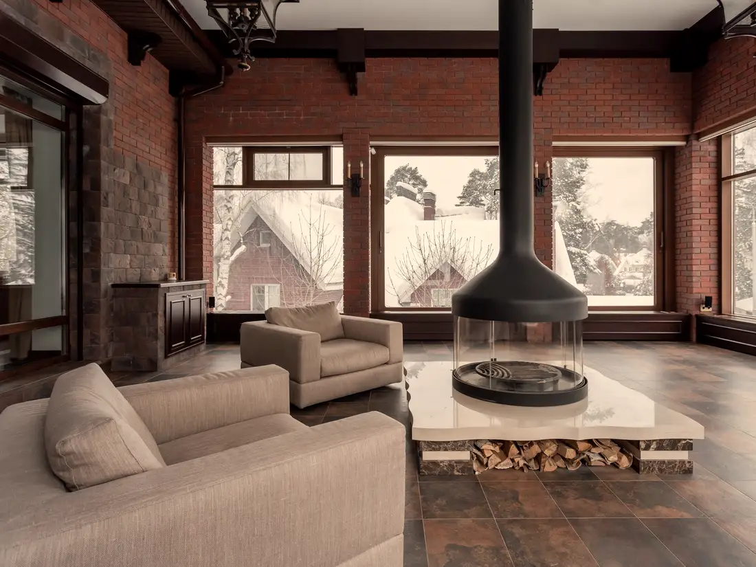 Living room with a fireplace and tall windows looking onto snow