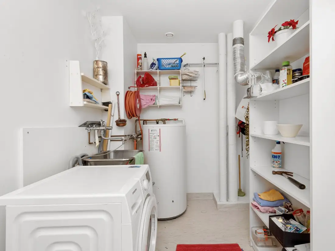 Laundry room with a water heater tank beside the washer